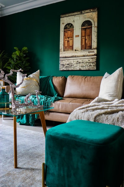 Beige leather sofa and green footstool
